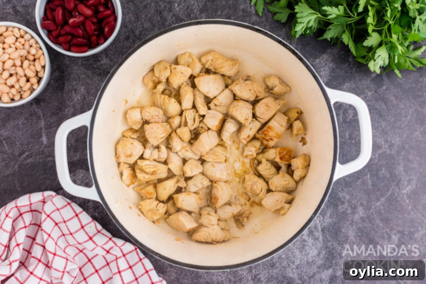 Sautéing cubed chicken in olive oil in a Dutch oven until lightly browned