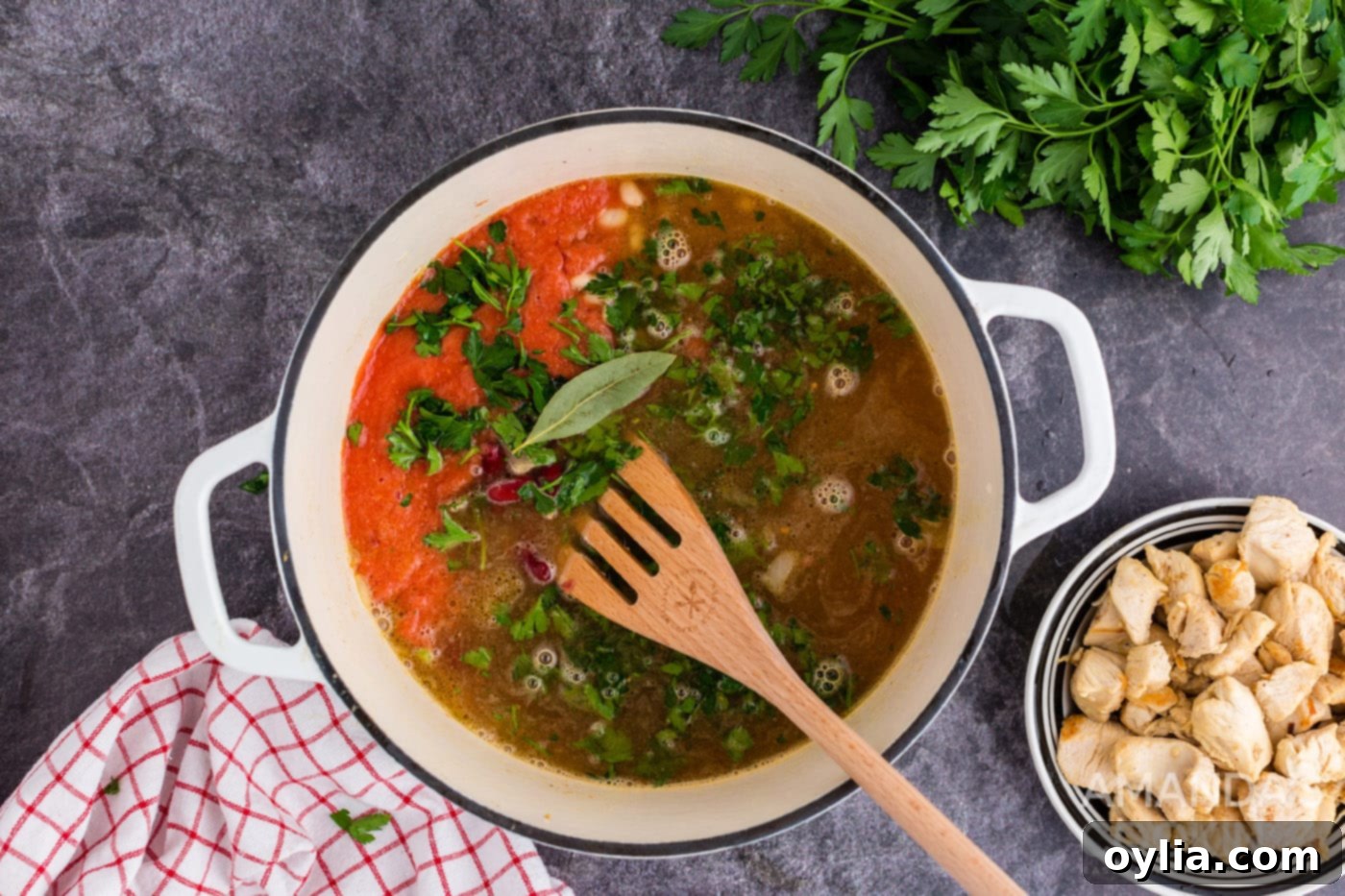 Bringing chicken bean soup ingredients to a boil in a Dutch oven