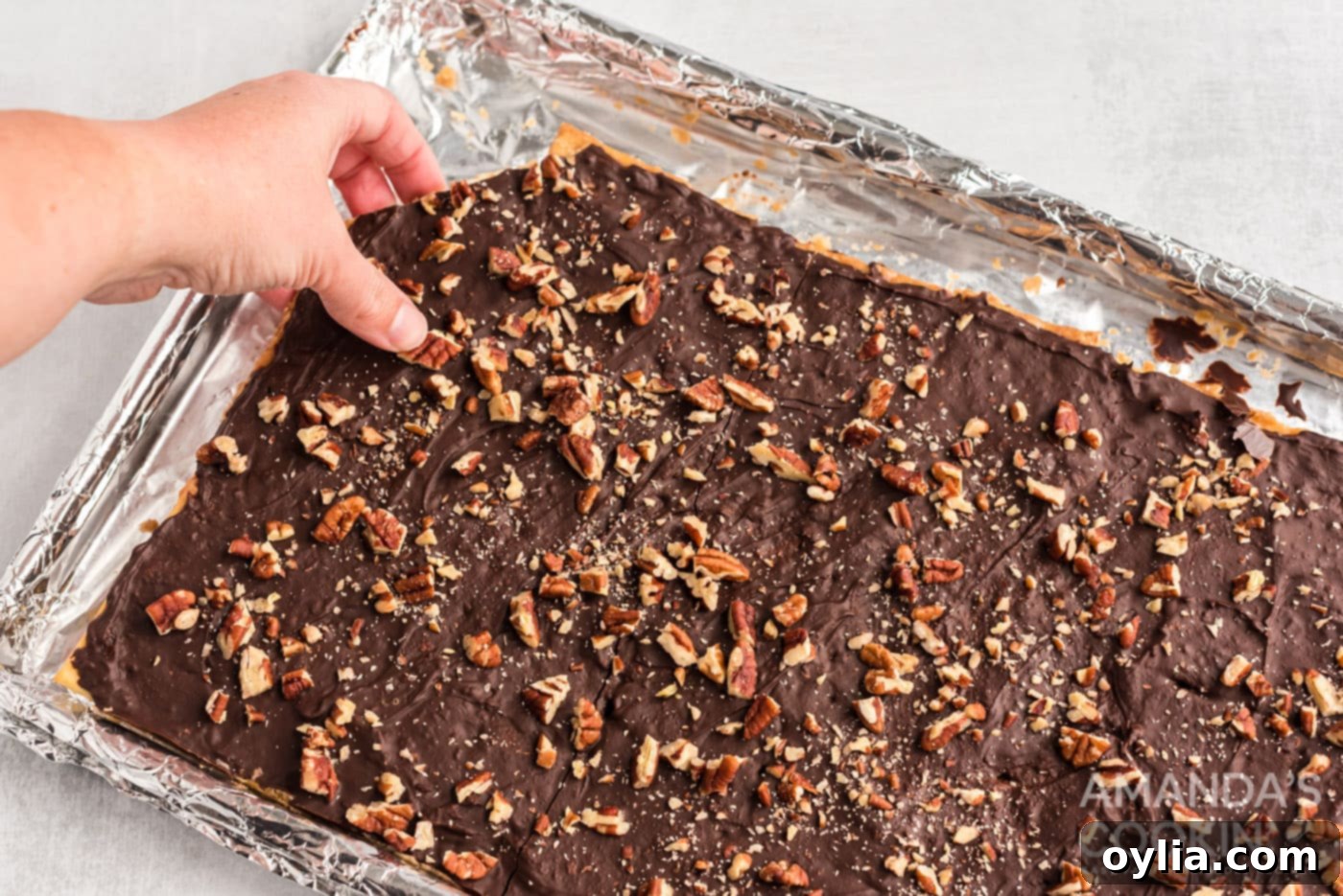hand breaking off a piece of saltine toffee
