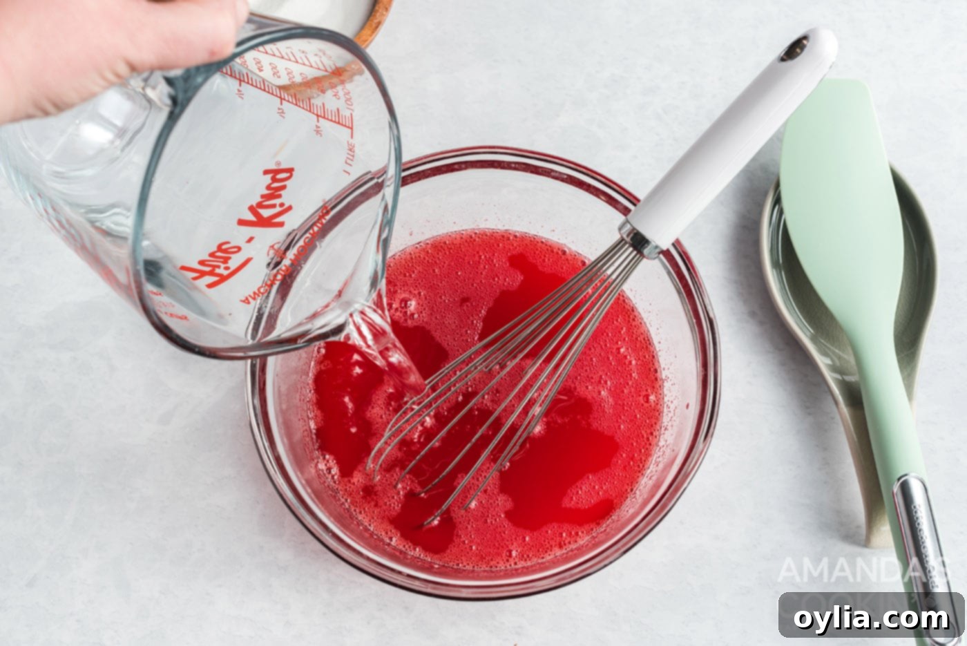 adding cold water to strawberry jello