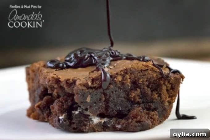 A close up photo of chocolate sauce being drizzled on a peppermint patty brownie.