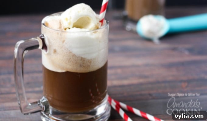A photo of a root beer float cocktail in a clear mug served with a red and white striped straw.
