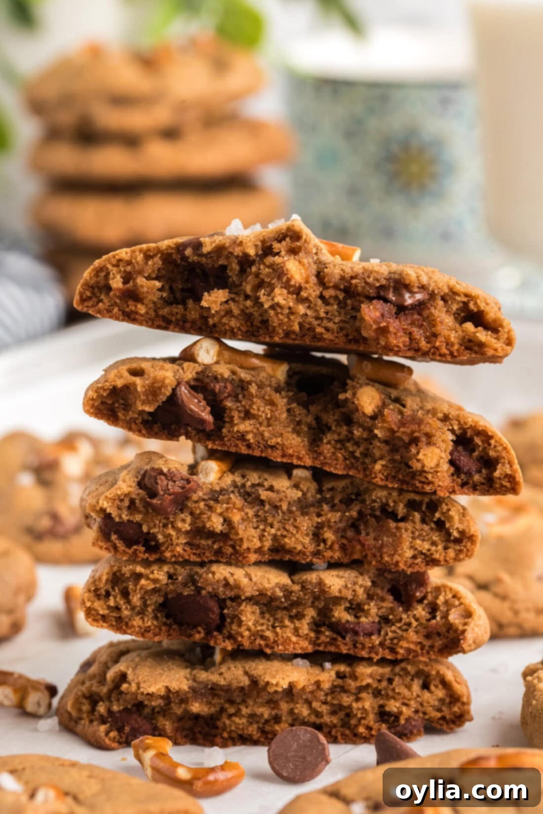 Stack of Pretzel Chocolate Chip Cookies cut in half, revealing the soft interior, melted chocolate, and crunchy pretzel pieces.
