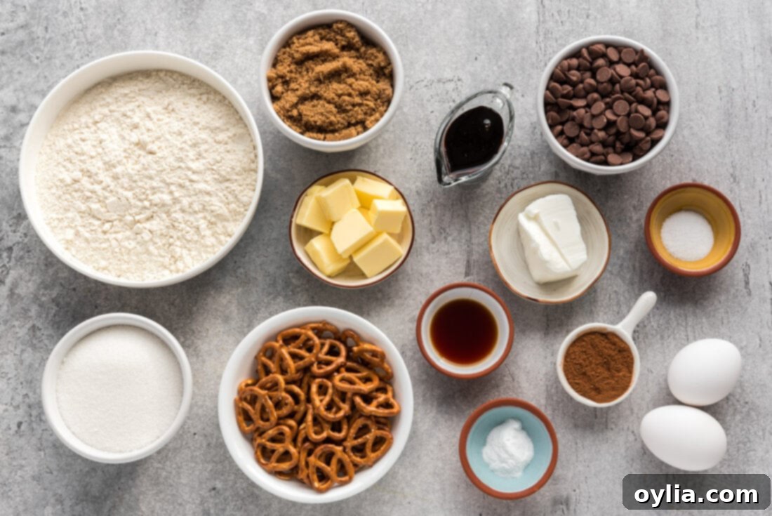 A flat lay of all ingredients for Pretzel Chocolate Chip Cookies, including flour, sugars, butter, chocolate chips, and pretzels.