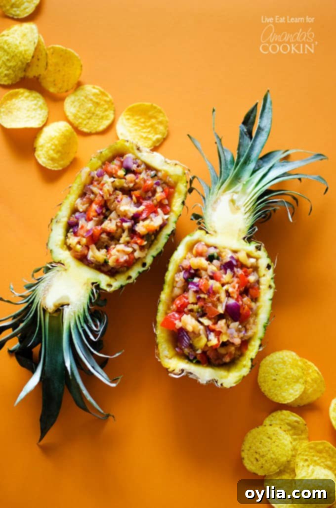 An overhead photo of beautifully arranged pineapple salsa served in halved pineapples, showcasing its vibrant colors.