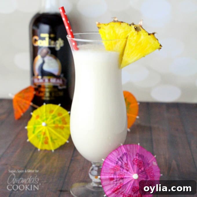 A refreshing Pina Colada cocktail in a tall glass, garnished with a fresh pineapple wedge and a maraschino cherry.