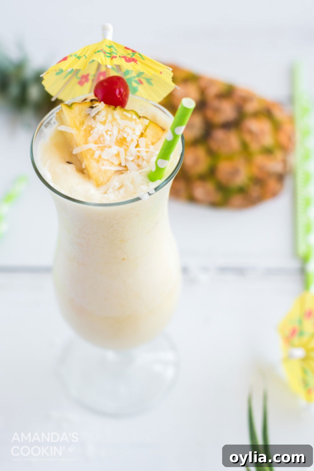 A pristine white Pina Colada, garnished with a red cherry and a pineapple wedge, capturing its classic appeal.