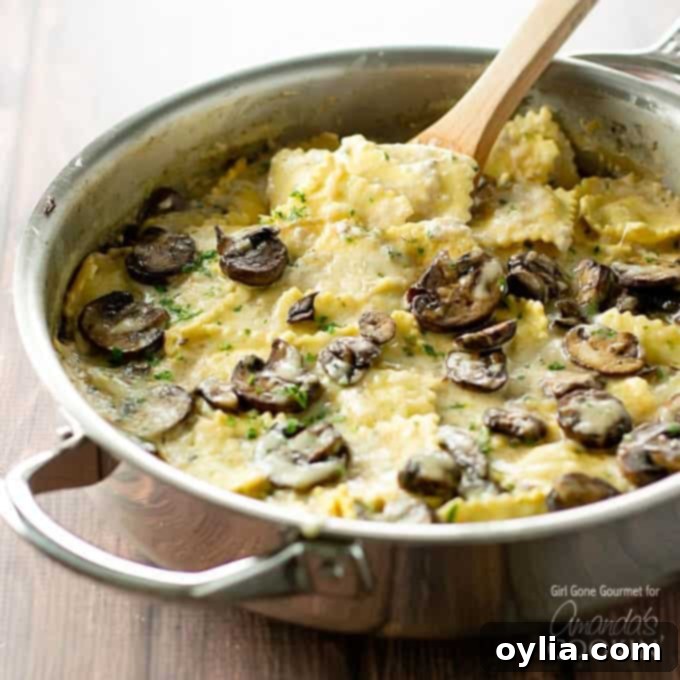 This creamy mushroom ravioli dish starts on the stove and finishes in the oven making it the perfect weeknight dinner. A stovetop casserole! Close-up of creamy mushroom ravioli bubbling in an oven-safe pan, showing rich sauce and tender pasta