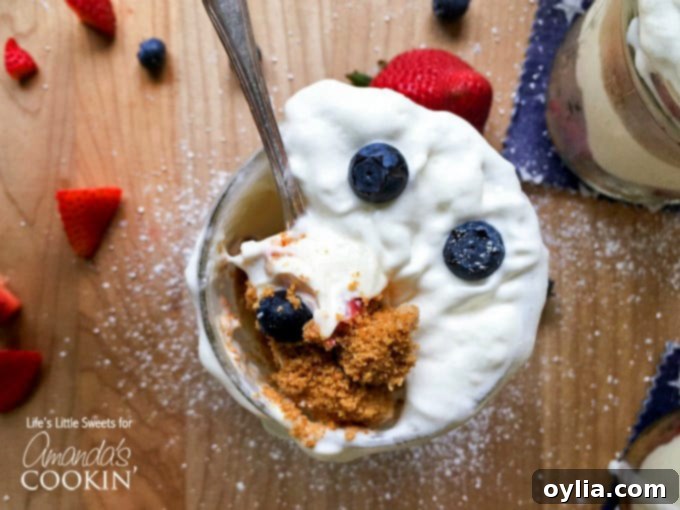 An overhead photo of a spoonful of no bake berry cheesecake trifle in a mason jar.