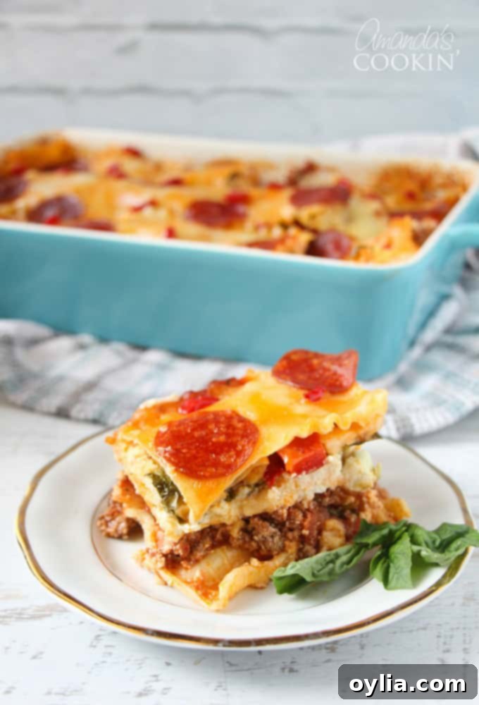 A close up photo of a slice of pizza lasagna on a white and gold plate, with the full casserole pan blurred in the background.
