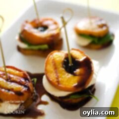 A close up of grilled peach caprese on a white platter.