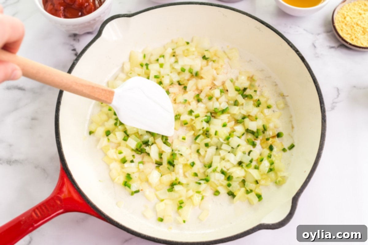 Perfectly Homemade Baked Beans 4 A skillet containing finely chopped onion and jalapeño sautéing in a small amount of bacon grease.