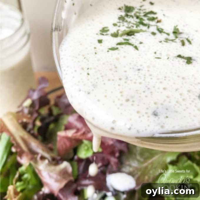 Salad dressing being poured from a glass