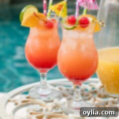 two glasses of rum punch poolside with a pitcher
