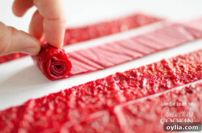 A close up of homemade fruit roll ups being rolled.