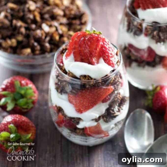 A close up photo of breakfast parfaits with strawberries and dark chocolate granola.