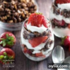 A close up photo of breakfast parfaits with strawberries and dark chocolate granola.