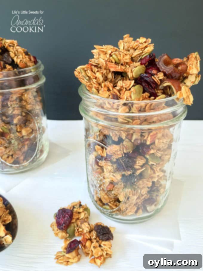 A close up photo of autumn harvest fruit and nut granola in a mason jar.