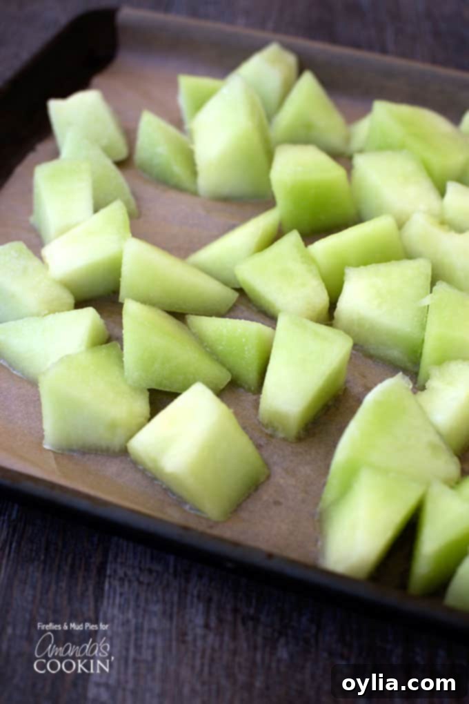 A vibrant close-up photograph showcasing fresh honeydew melon, perfectly chopped into small, bite-sized cubes, ready for freezing or immediate use in your refreshing slush.