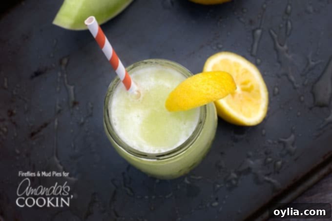 An inviting overhead view of a mason jar filled with the delightful honeydew lemon slush, beautifully garnished with a lemon wedge and served with a charming red and white striped straw.