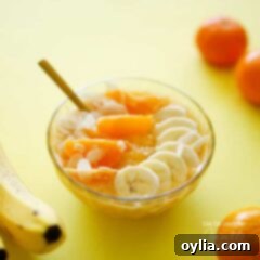 A photo of an almond orange smoothie bowl topped with fresh orange and bananas.