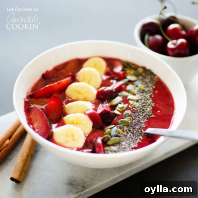 A close up photo of a thick stone fruit smoothie in a white bowl, richly garnished with colorful sliced plums, ripe cherries, banana slices, and a sprinkle of crunchy mixed nuts and seeds, ready to be enjoyed as a wholesome breakfast.