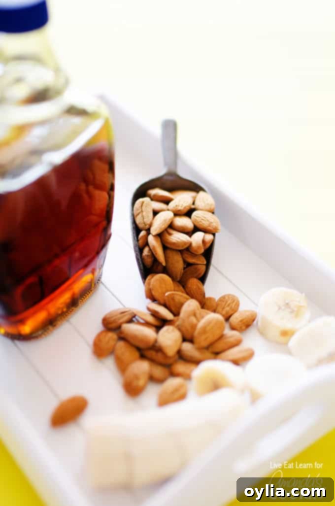 A close up photo of a jar of maple syrup and a scoop of almonds.