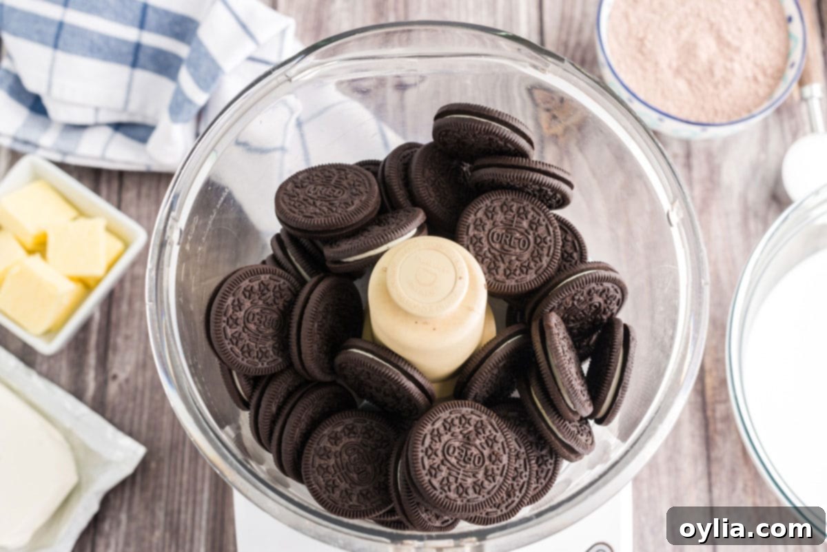 Decadent Chocolate Lasagna 3 oreo cookies in the bowl of a food processor before crushing