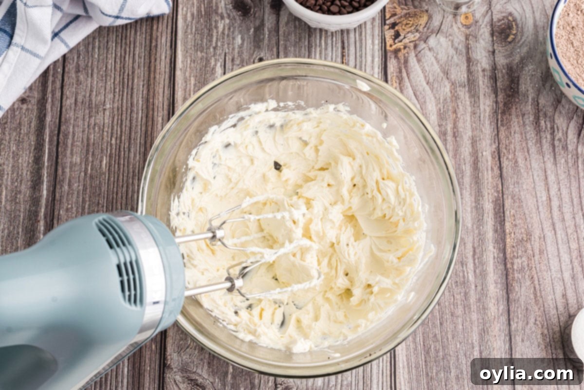 Decadent Chocolate Lasagna 7 beating softened cream cheese until fluffy in a bowl with a hand mixer
