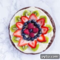 An overhead photo of fruit cut up on top of a brownie pizza.