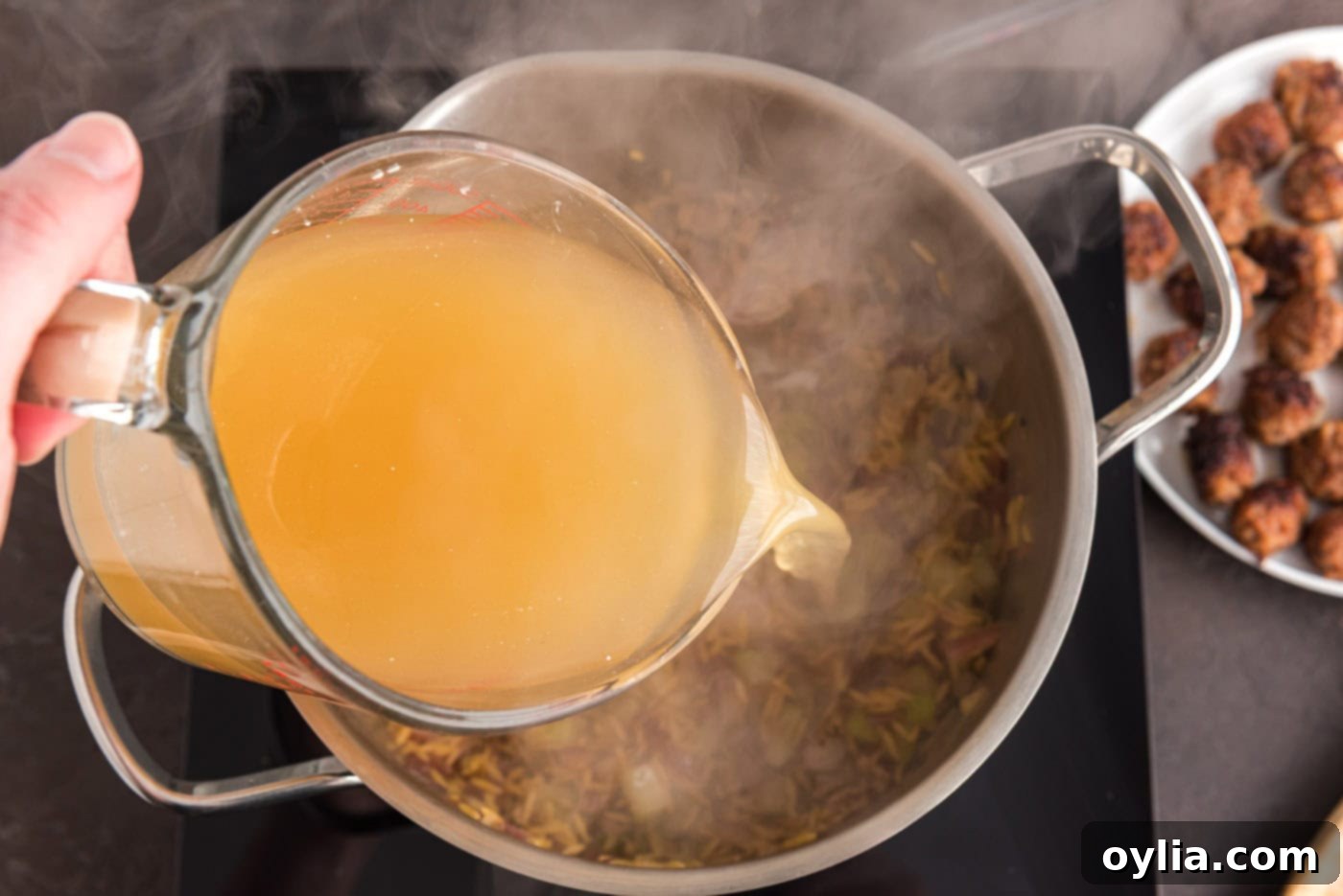 pouring chicken broth into stock pot
