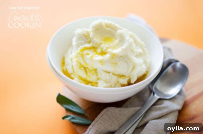 A white bowl filled with mashed cauliflower and melted butter on top.