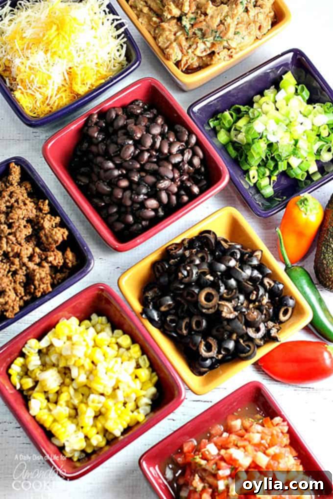 A variety of square bowls filled with taco meat, corn, black beans, black olives, green onions and cheese.