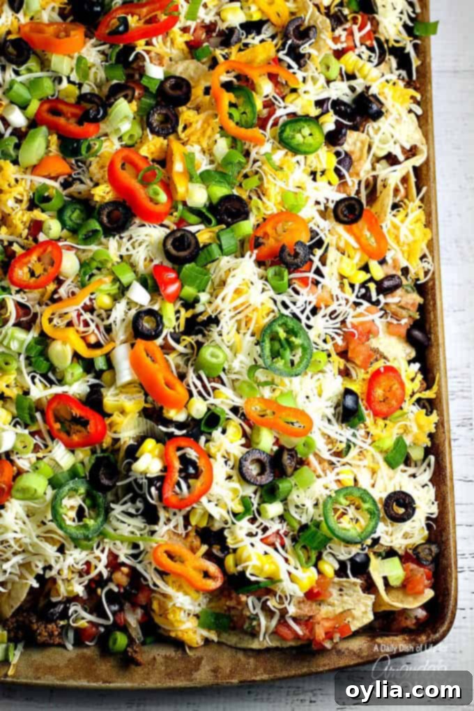 An overhead of loaded nachos on a baking sheet.