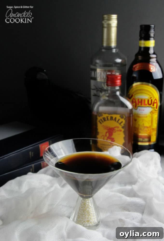 A photo of a raven coffee cocktail in a martini glass, garnished with a dark feather.