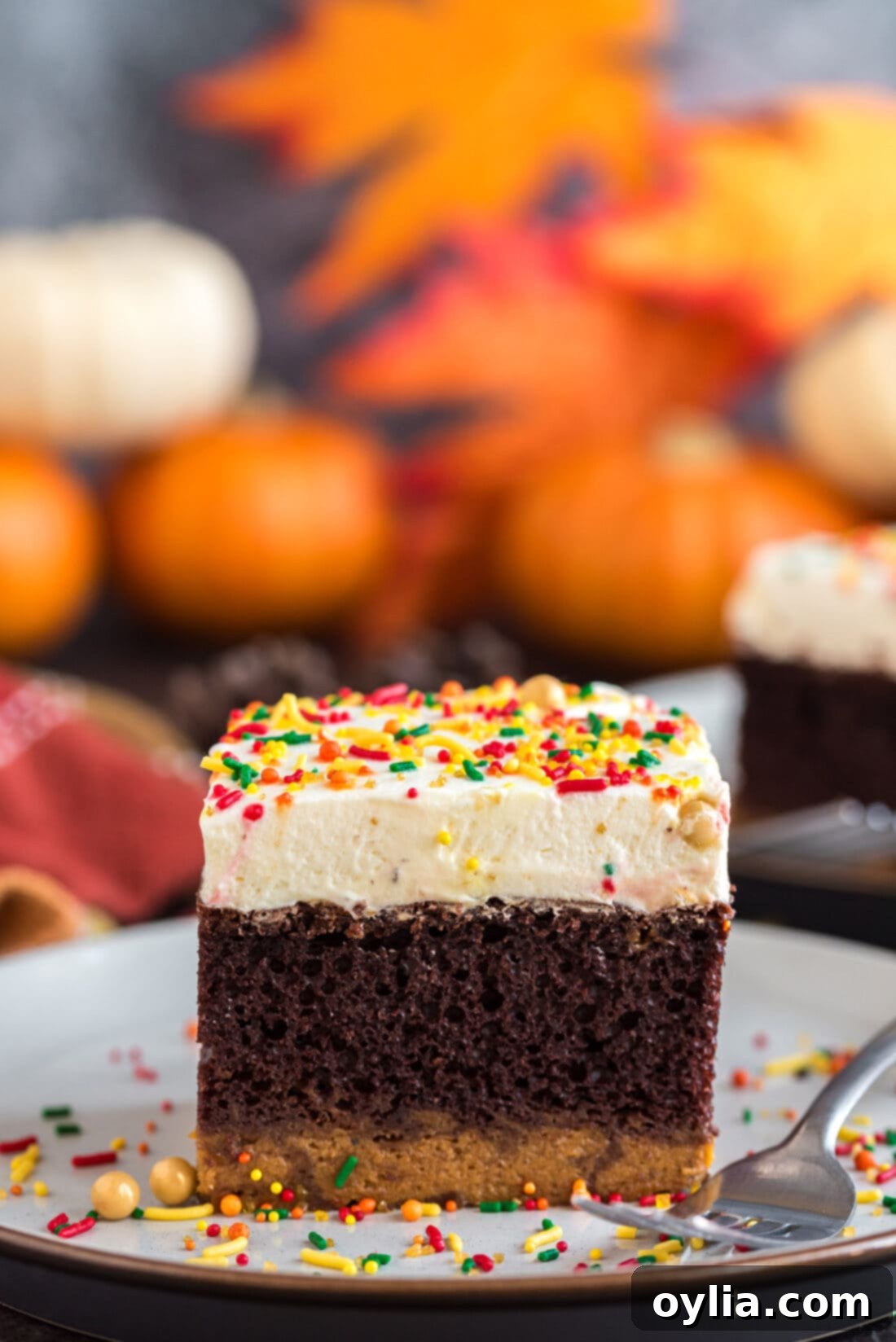Square piece of Chocolate Pumpkin Magic Cake on a plate with a fork, showcasing its three distinct layers