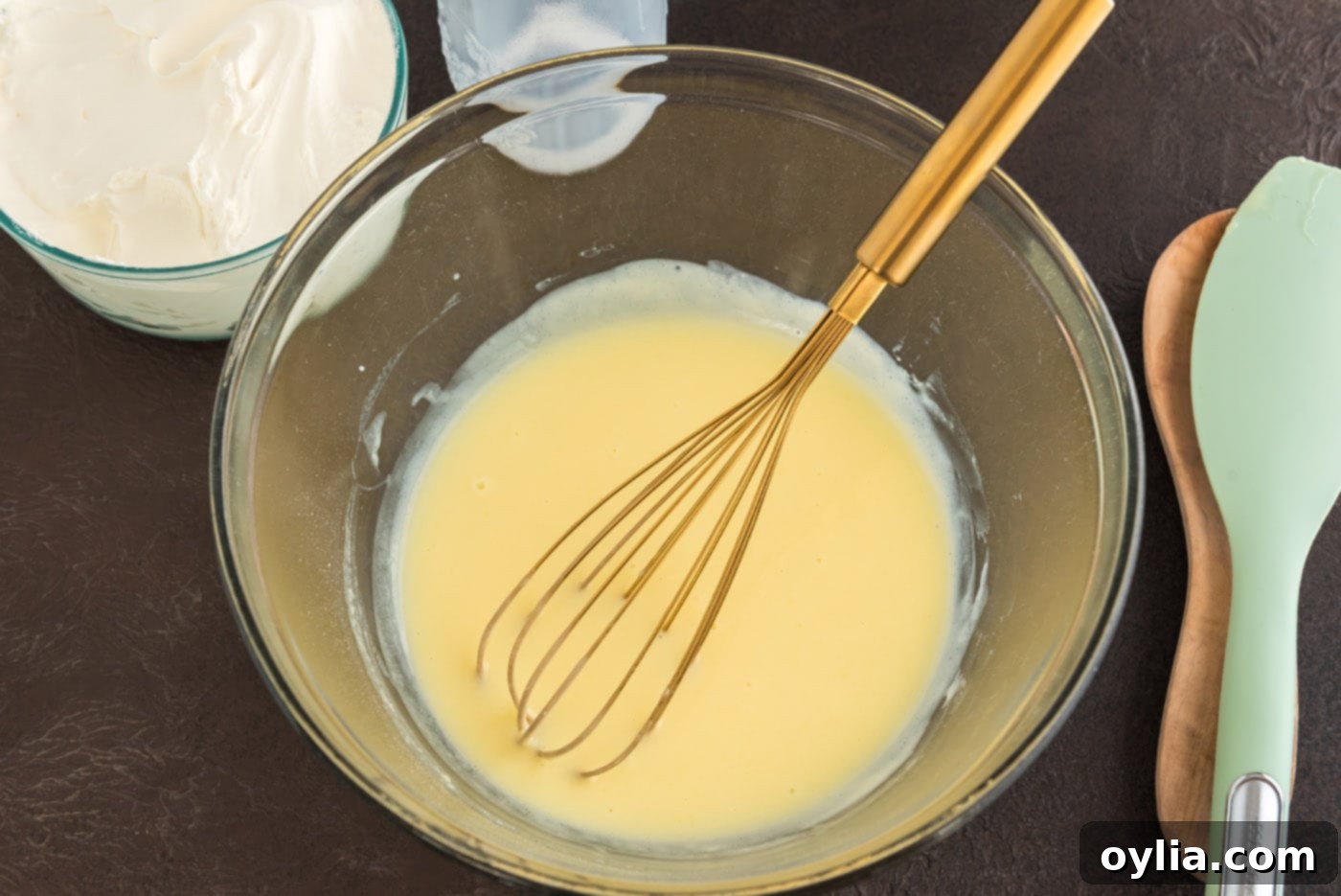 vanilla instant pudding mix in a bowl with cold milk, ready to be whisked