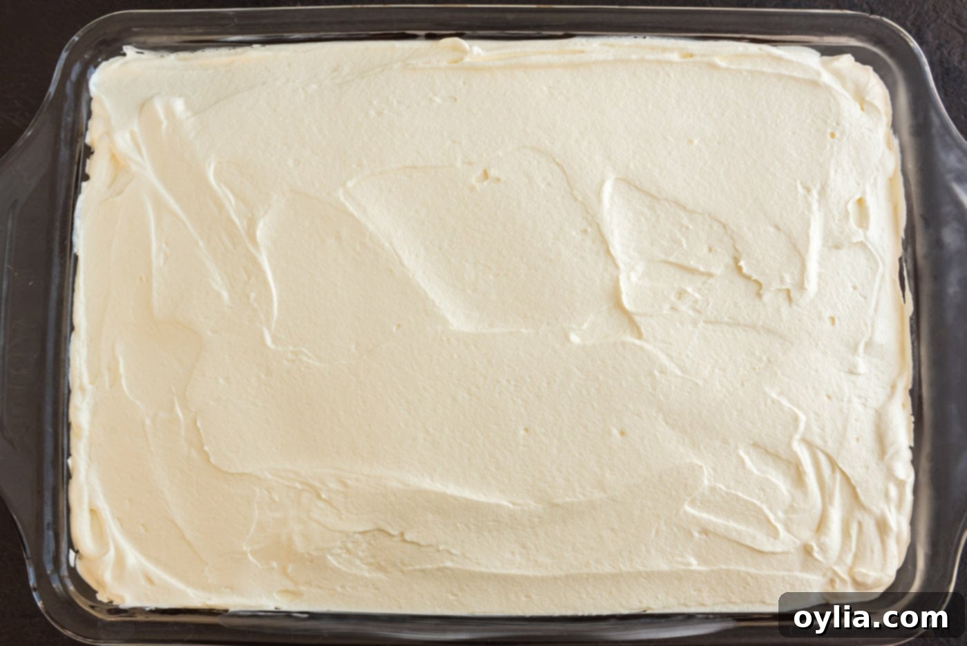 vanilla mousse being spread over the cooled chocolate pumpkin magic cake
