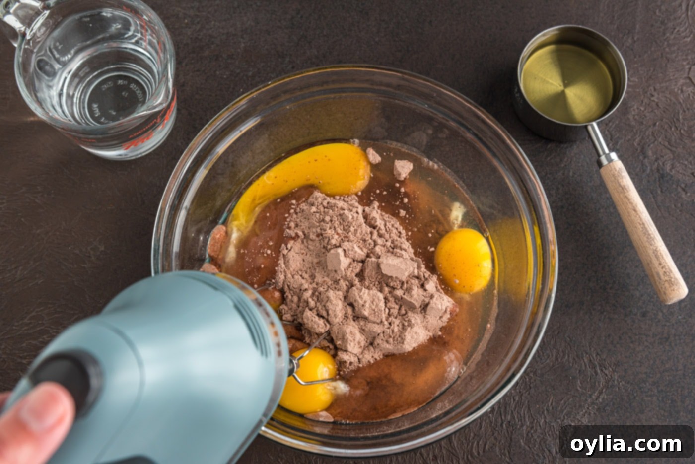 mixing cake mix with eggs, oil, and water with an electric mixer until smooth
