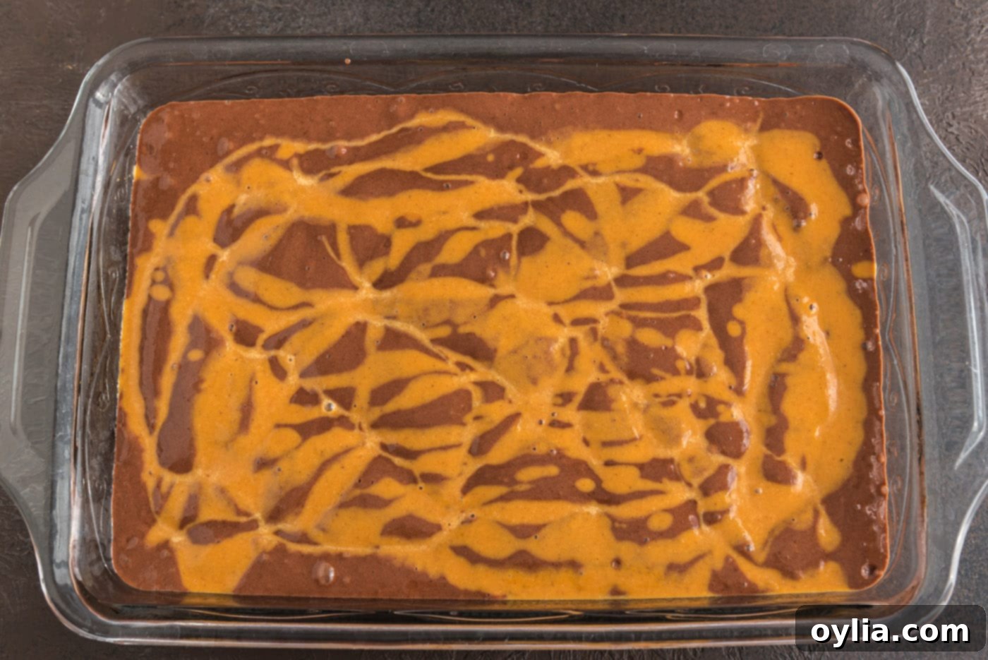 pumpkin pie mixture slowly drizzled over the chocolate cake mix in the baking dish