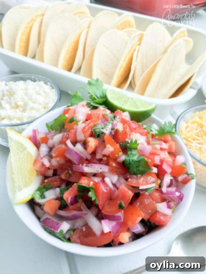 A close-up photo of a fresh, vibrant bowl of homemade salsa, brimming with diced red tomatoes, chopped red onion, and fresh cilantro, ready to accompany delicious salmon tacos.