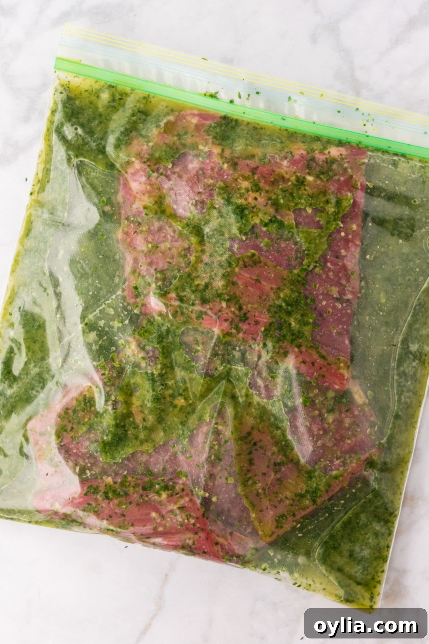 Carne Asada Marinade poured over steak in a dish