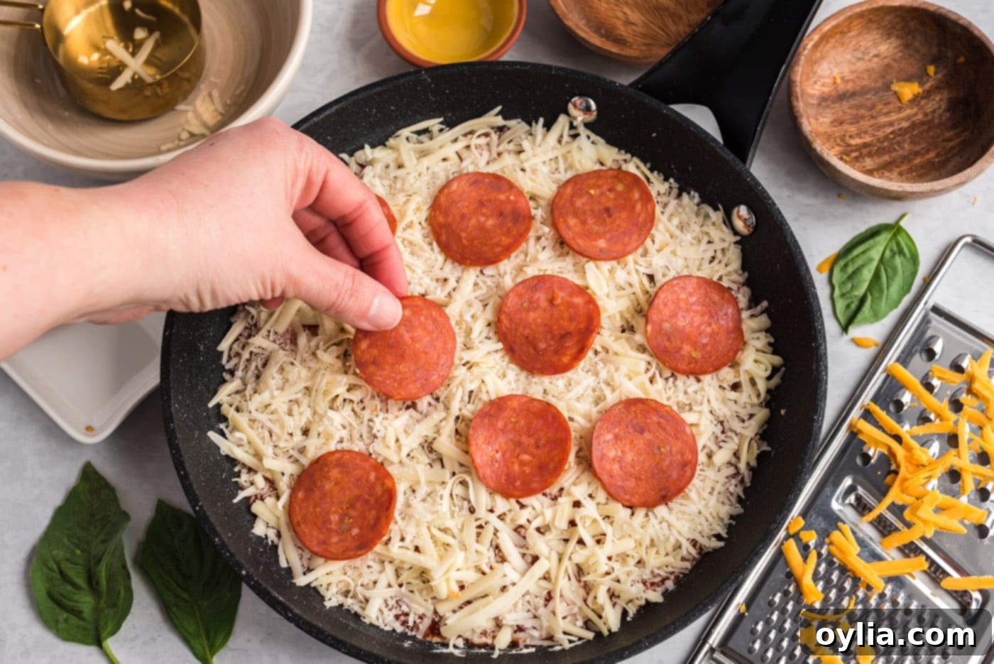 adding pepperoni slices as a topping to the pizza dip
