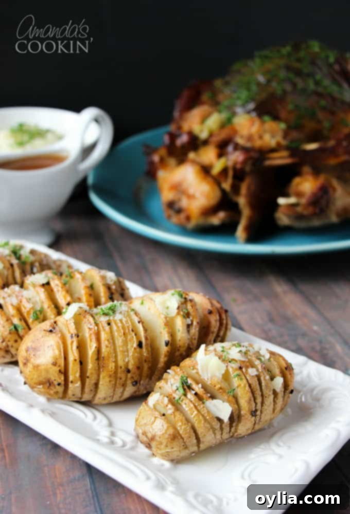 Hasselback potatoes resting on a rectangular white plate.