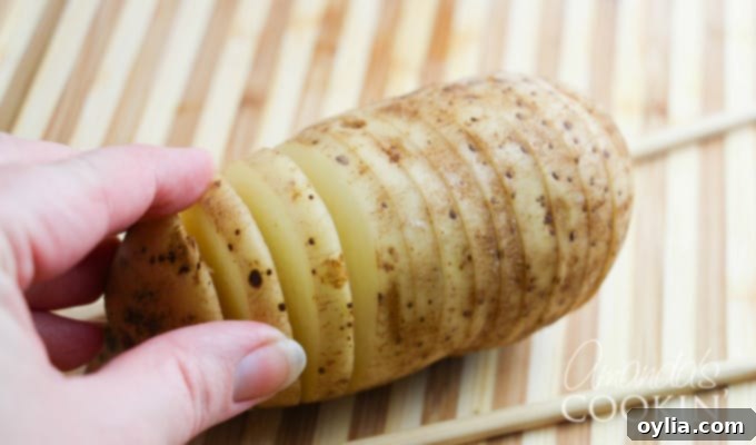 Hasselback potatoes step 1: demonstrating how to make cuts with chopsticks.