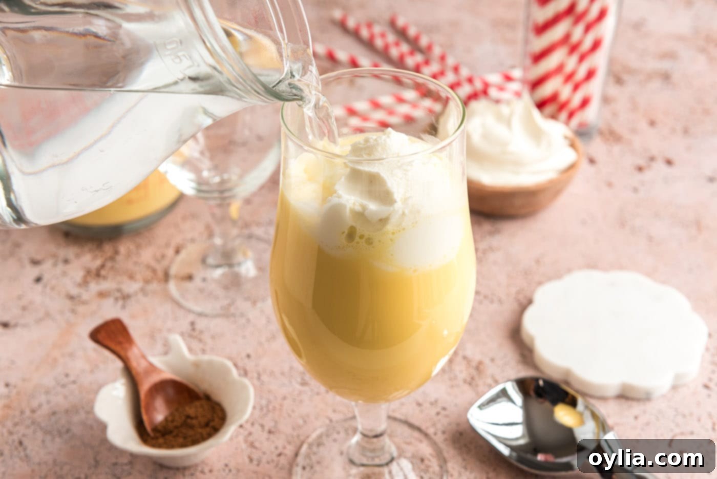 pouring club soda into glass of eggnog and ice cream