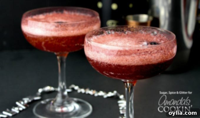 Horizontal shot of a single Blackberry Rum Champagne Cocktail in an elegant old-fashioned glass, garnished with fresh berries.