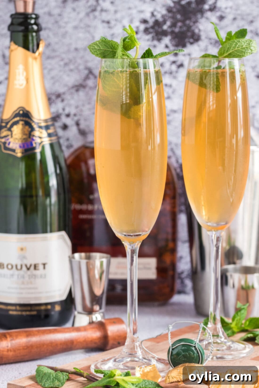 Two Fizzy Julep cocktails with extra champagne in the background
