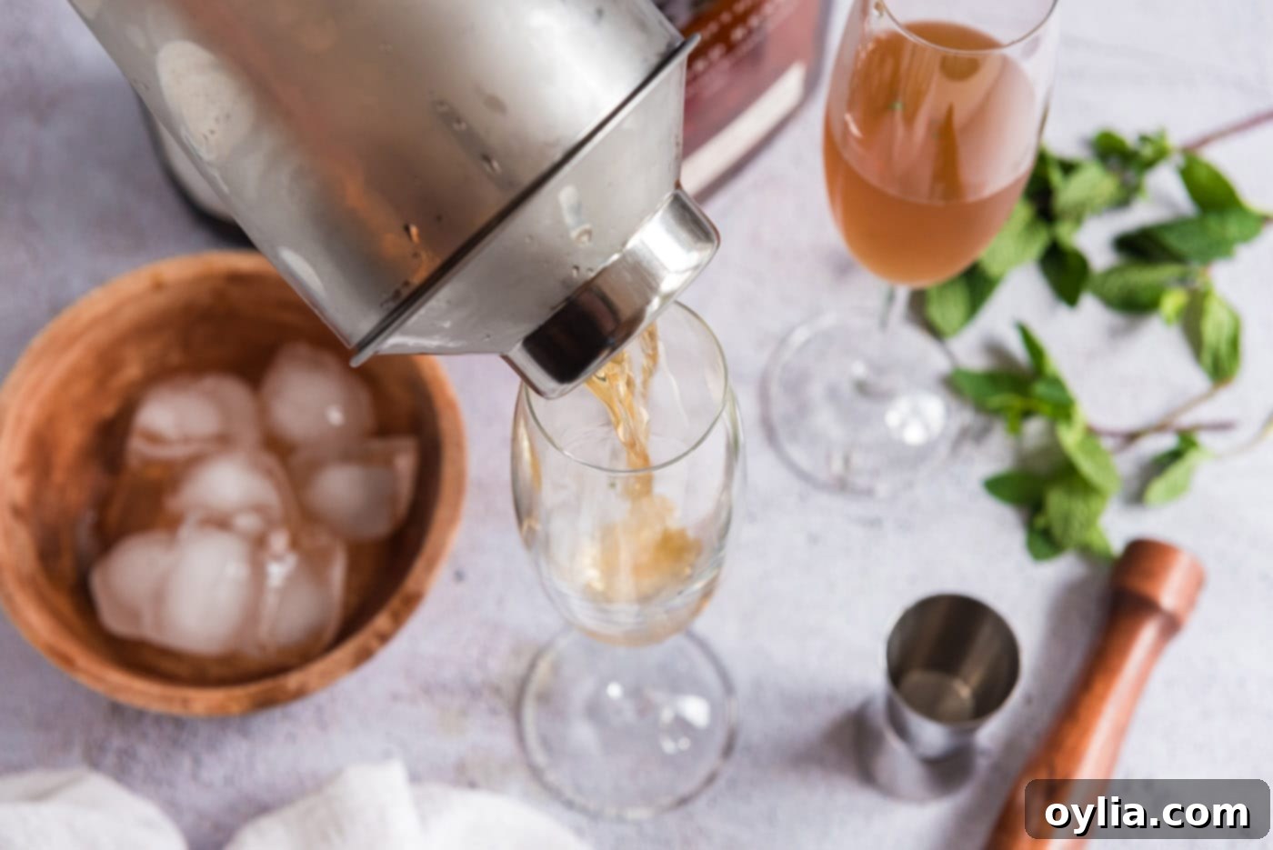 pouring mint julep into champagne glass