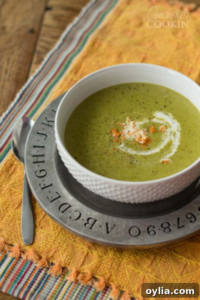 An overhead shot of a white bowl filled with creamy asparagus soup, ready to be served.